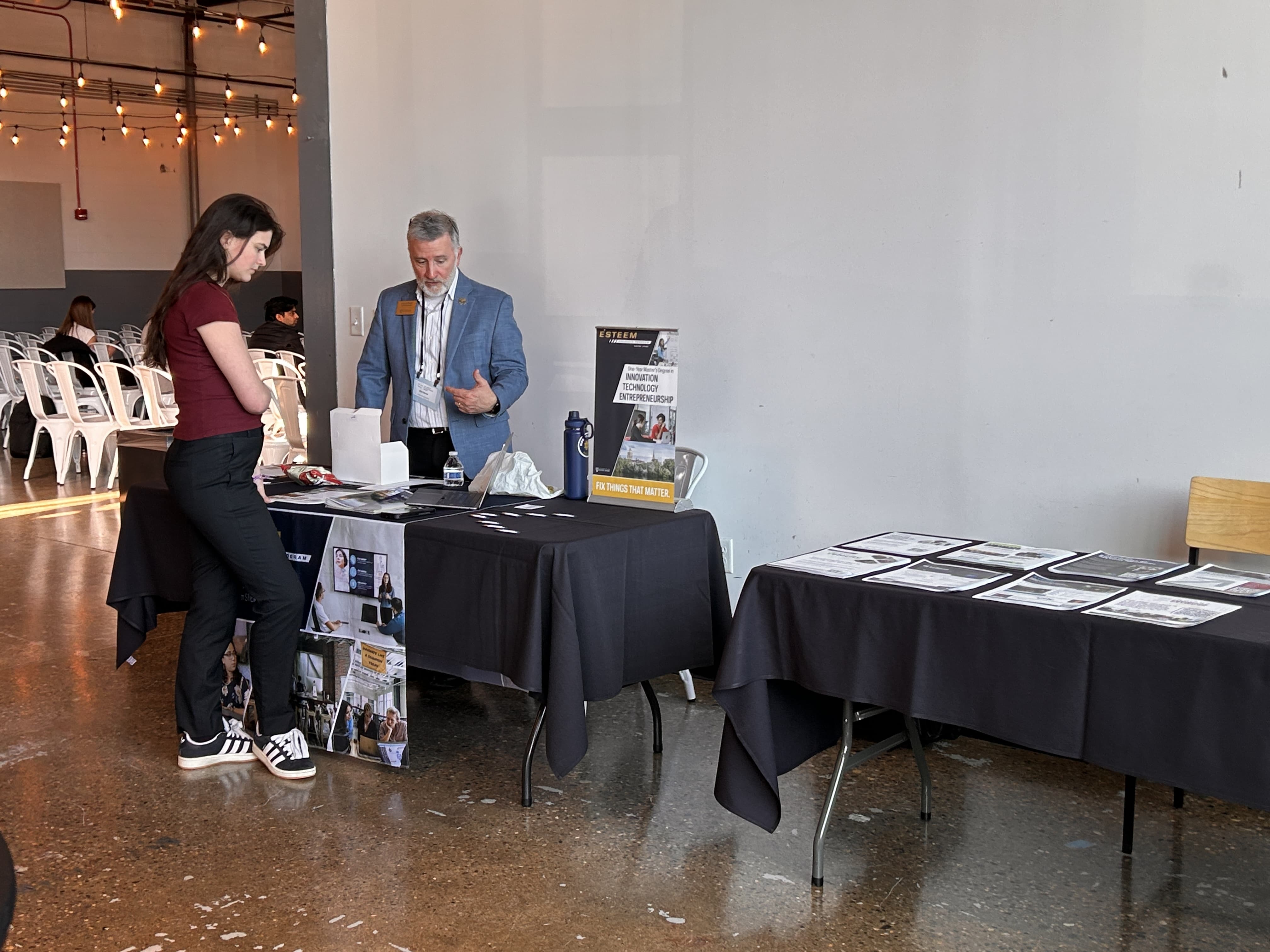 An attendee speaking with an exhibitor at the summit